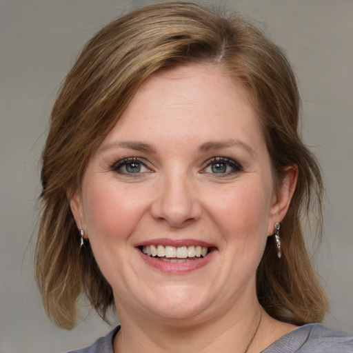 Joyful white adult female with medium  brown hair and blue eyes