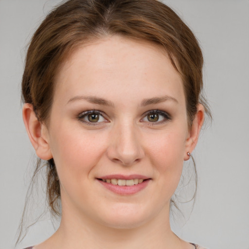 Joyful white young-adult female with medium  brown hair and green eyes