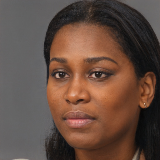 Joyful black young-adult female with long  brown hair and brown eyes