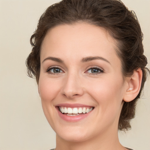 Joyful white young-adult female with medium  brown hair and green eyes