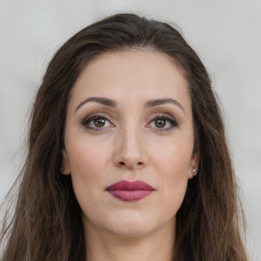 Joyful white young-adult female with long  brown hair and brown eyes