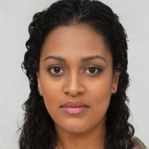 Joyful black young-adult female with long  brown hair and brown eyes