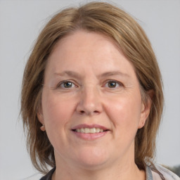 Joyful white adult female with medium  brown hair and blue eyes