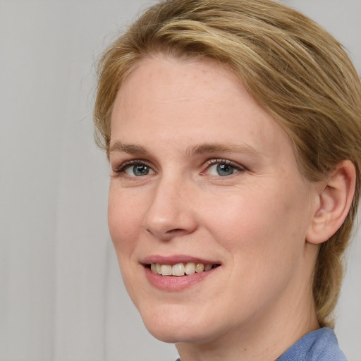 Joyful white young-adult female with medium  brown hair and blue eyes