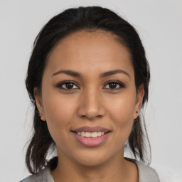 Joyful latino young-adult female with medium  brown hair and brown eyes