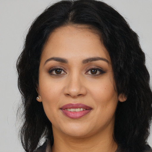 Joyful latino young-adult female with long  black hair and brown eyes