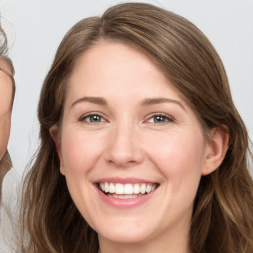 Joyful white young-adult female with long  brown hair and grey eyes