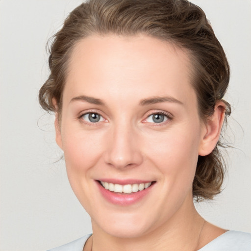 Joyful white young-adult female with medium  brown hair and blue eyes