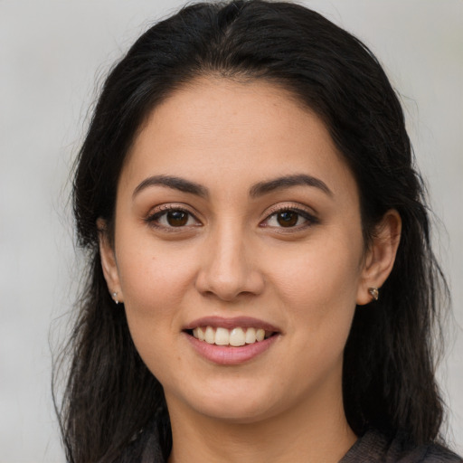 Joyful latino young-adult female with long  brown hair and brown eyes