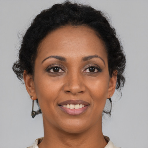 Joyful black young-adult female with medium  brown hair and brown eyes