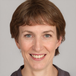 Joyful white adult female with medium  brown hair and grey eyes