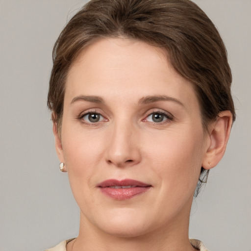 Joyful white young-adult female with medium  brown hair and grey eyes