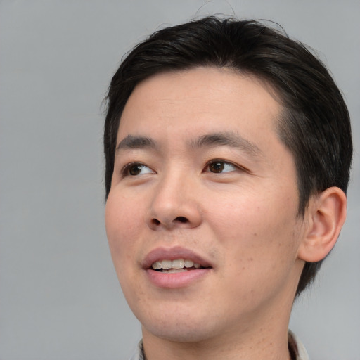 Joyful asian young-adult male with short  brown hair and brown eyes