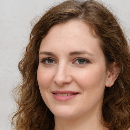 Joyful white young-adult female with long  brown hair and green eyes