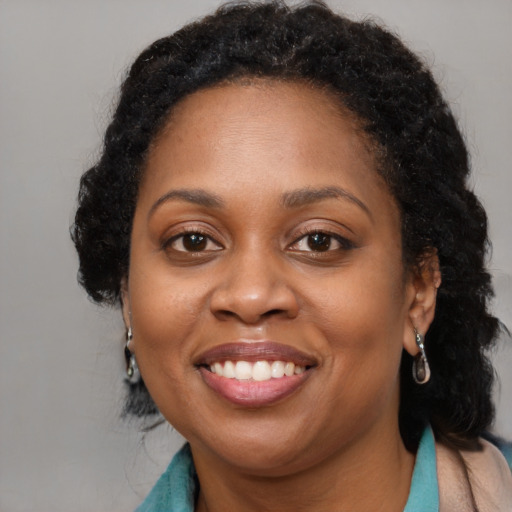 Joyful black adult female with long  brown hair and brown eyes