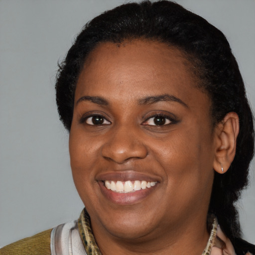 Joyful black young-adult female with short  black hair and brown eyes