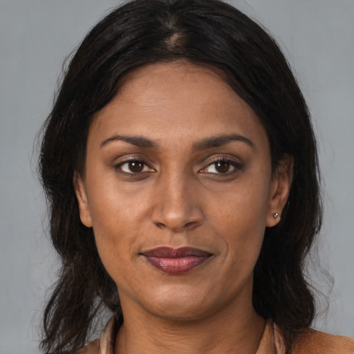 Joyful black adult female with medium  brown hair and brown eyes