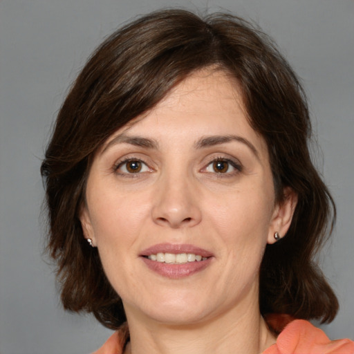 Joyful white adult female with medium  brown hair and brown eyes