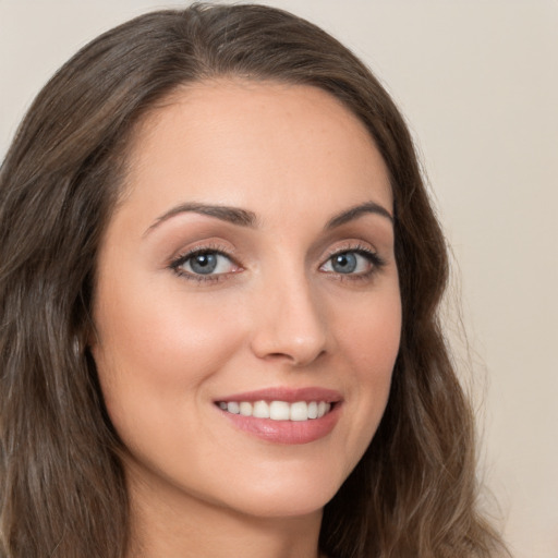 Joyful white young-adult female with long  brown hair and brown eyes