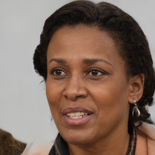 Joyful black adult female with medium  brown hair and brown eyes