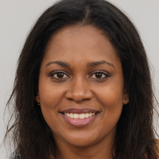 Joyful black young-adult female with long  brown hair and brown eyes