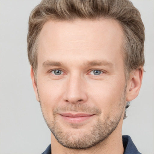 Joyful white young-adult male with short  brown hair and grey eyes