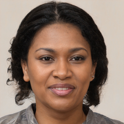 Joyful black adult female with medium  brown hair and brown eyes