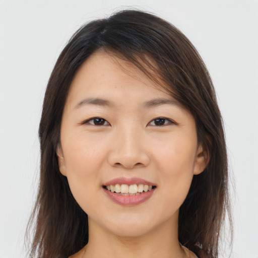 Joyful asian young-adult female with long  brown hair and brown eyes