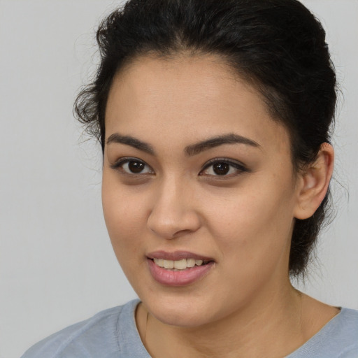 Joyful latino young-adult female with medium  brown hair and brown eyes