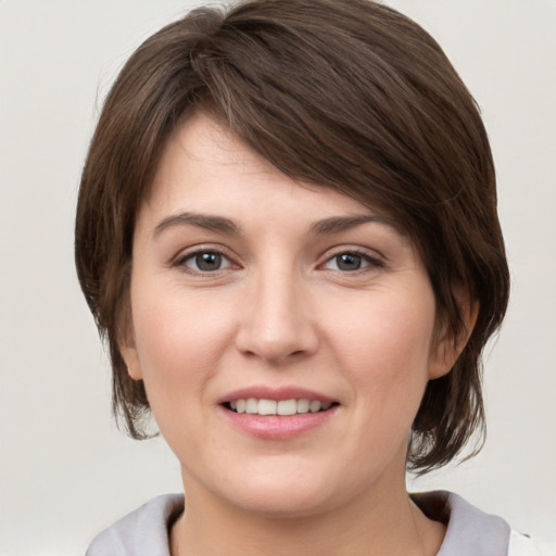 Joyful white young-adult female with medium  brown hair and grey eyes