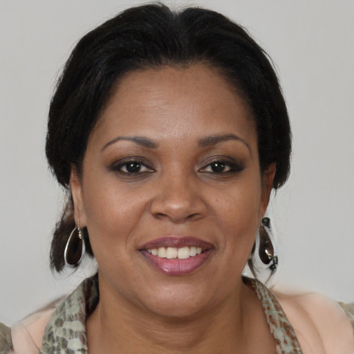 Joyful black adult female with medium  brown hair and brown eyes