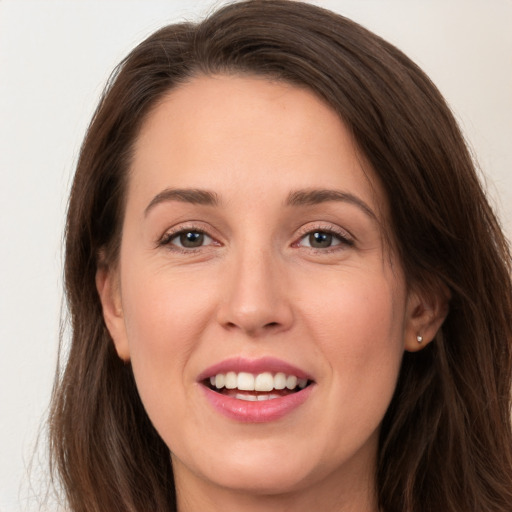 Joyful white young-adult female with long  brown hair and grey eyes