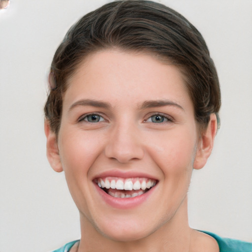 Joyful white young-adult female with short  brown hair and grey eyes