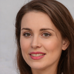 Joyful white young-adult female with long  brown hair and brown eyes