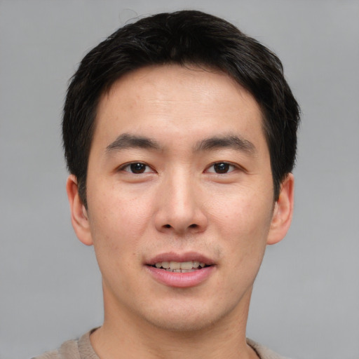 Joyful asian young-adult male with short  brown hair and brown eyes