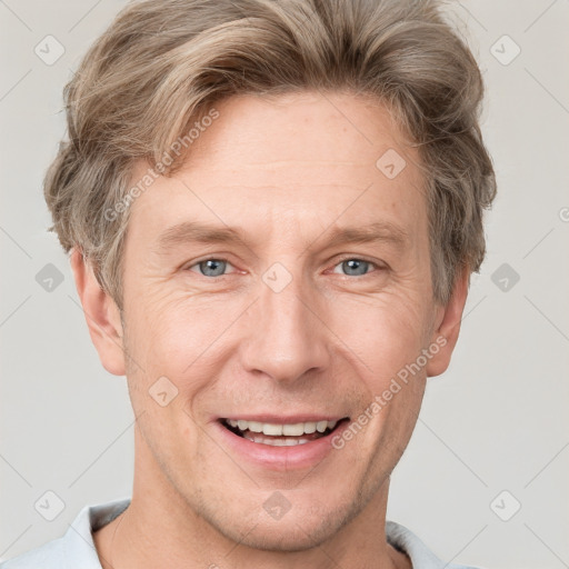 Joyful white adult male with short  brown hair and grey eyes