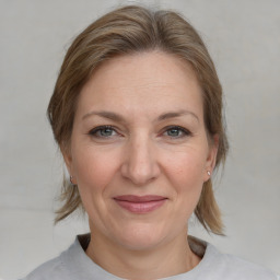 Joyful white adult female with medium  brown hair and grey eyes