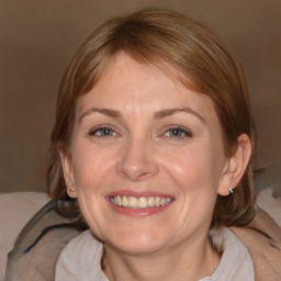 Joyful white adult female with medium  brown hair and blue eyes