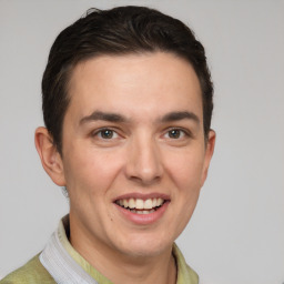 Joyful white young-adult male with short  brown hair and grey eyes