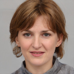 Joyful white young-adult female with medium  brown hair and grey eyes