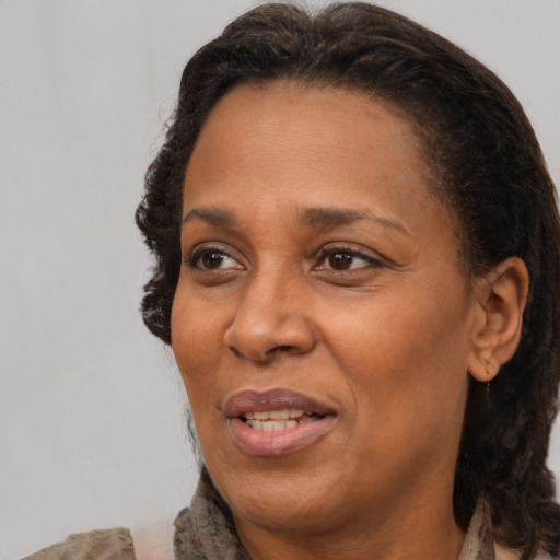 Joyful black adult female with medium  brown hair and brown eyes