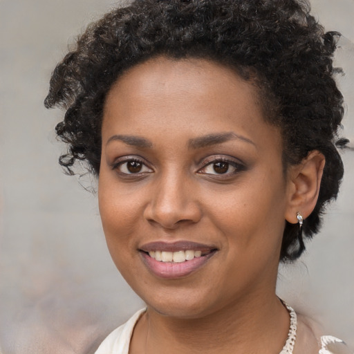 Joyful black young-adult female with short  brown hair and brown eyes