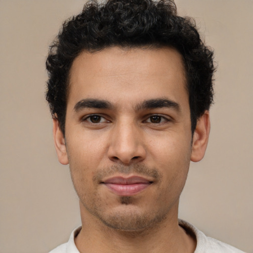 Joyful latino young-adult male with short  brown hair and brown eyes