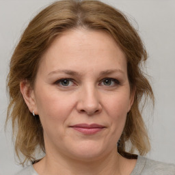 Joyful white adult female with medium  brown hair and grey eyes