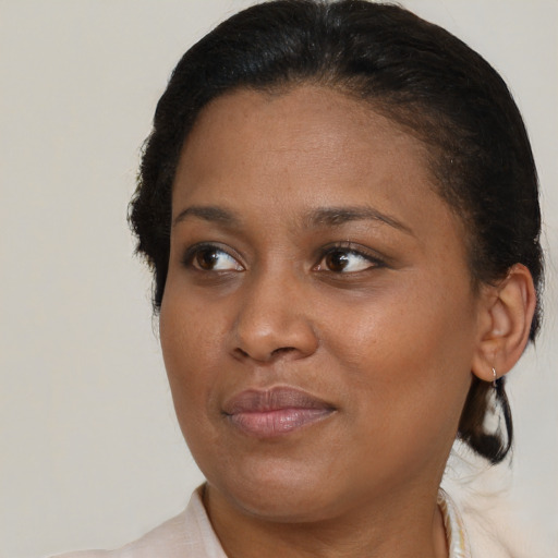 Joyful black adult female with medium  brown hair and brown eyes