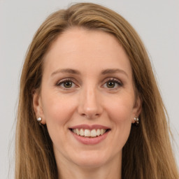 Joyful white young-adult female with long  brown hair and green eyes