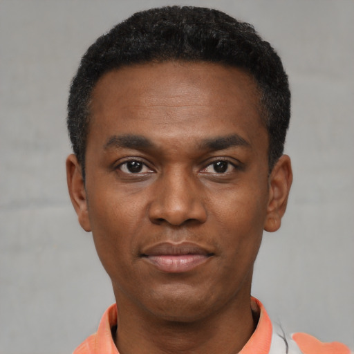 Joyful black young-adult male with short  black hair and brown eyes