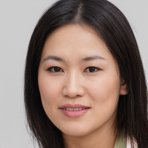 Joyful asian young-adult female with long  brown hair and brown eyes