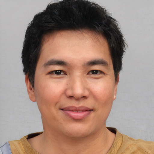 Joyful asian young-adult male with short  brown hair and brown eyes