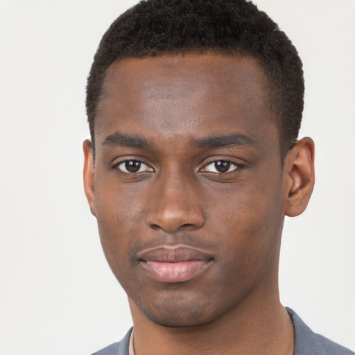 Joyful black young-adult male with short  brown hair and brown eyes